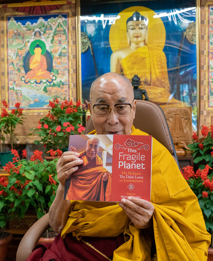 The Dalai Lama holding the book